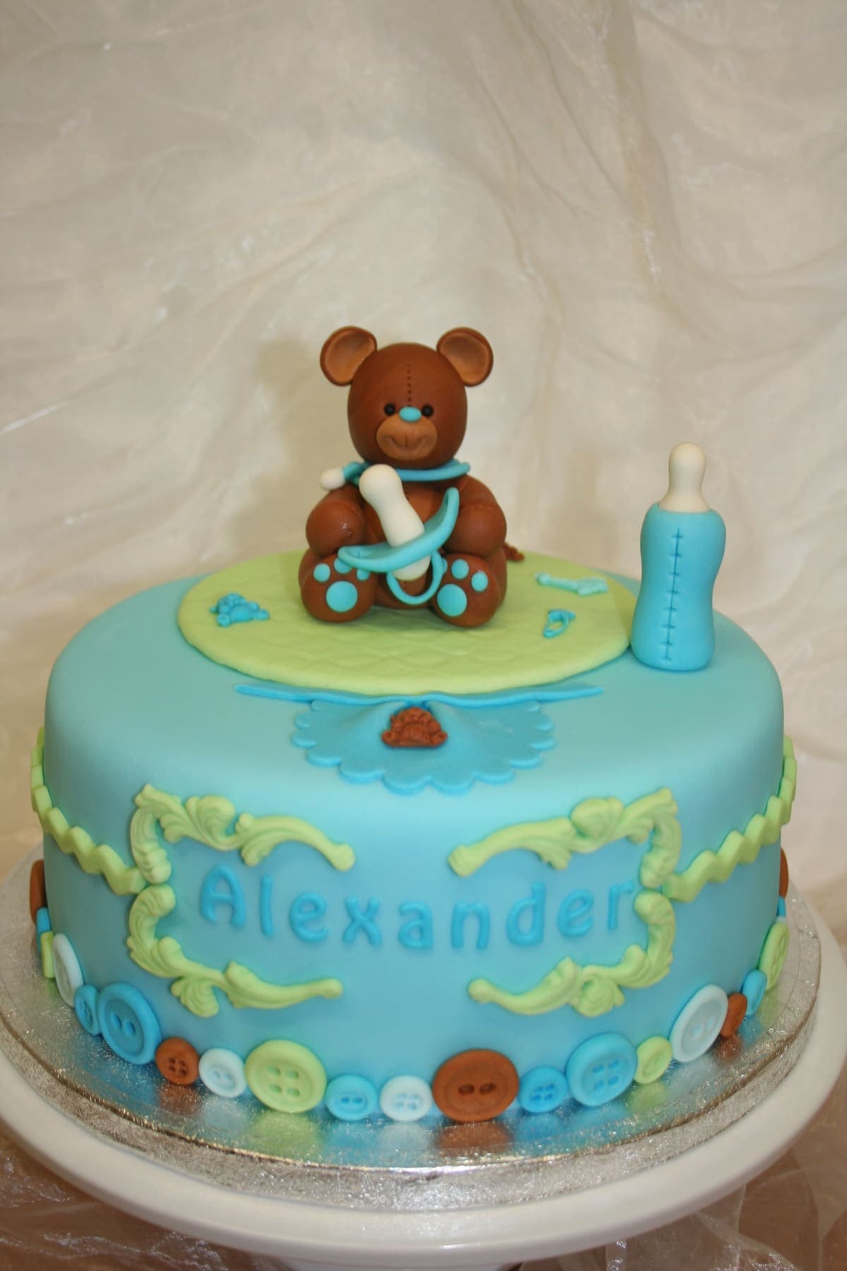 Süße Babytorte mit Teddybär, Fläschchen und Baby-Accessoires