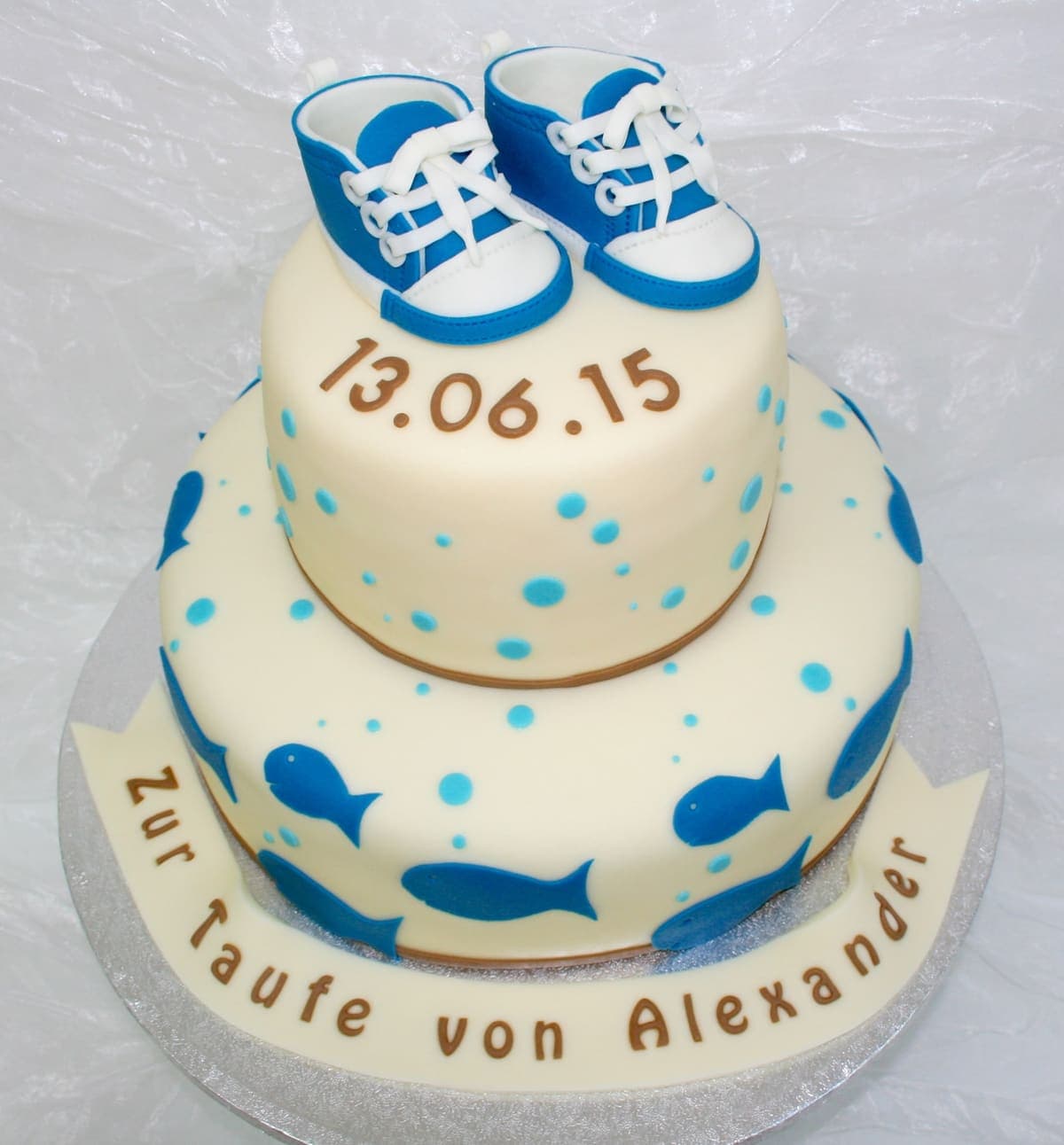 Zweistöckige Tauftorte mit blauen Babyschuhen und Fisch-Dekoration