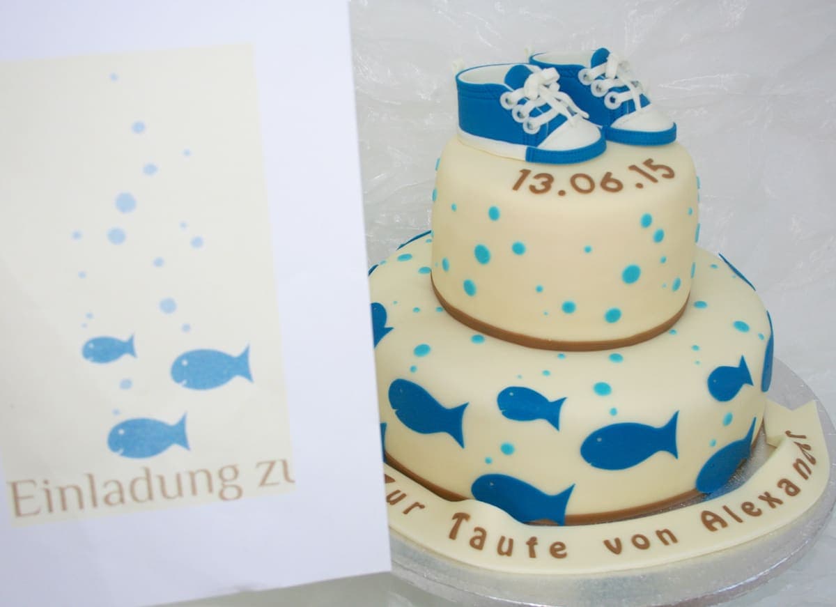 Zweistöckige Tauftorte mit blauen Fischen und Babyschuhen