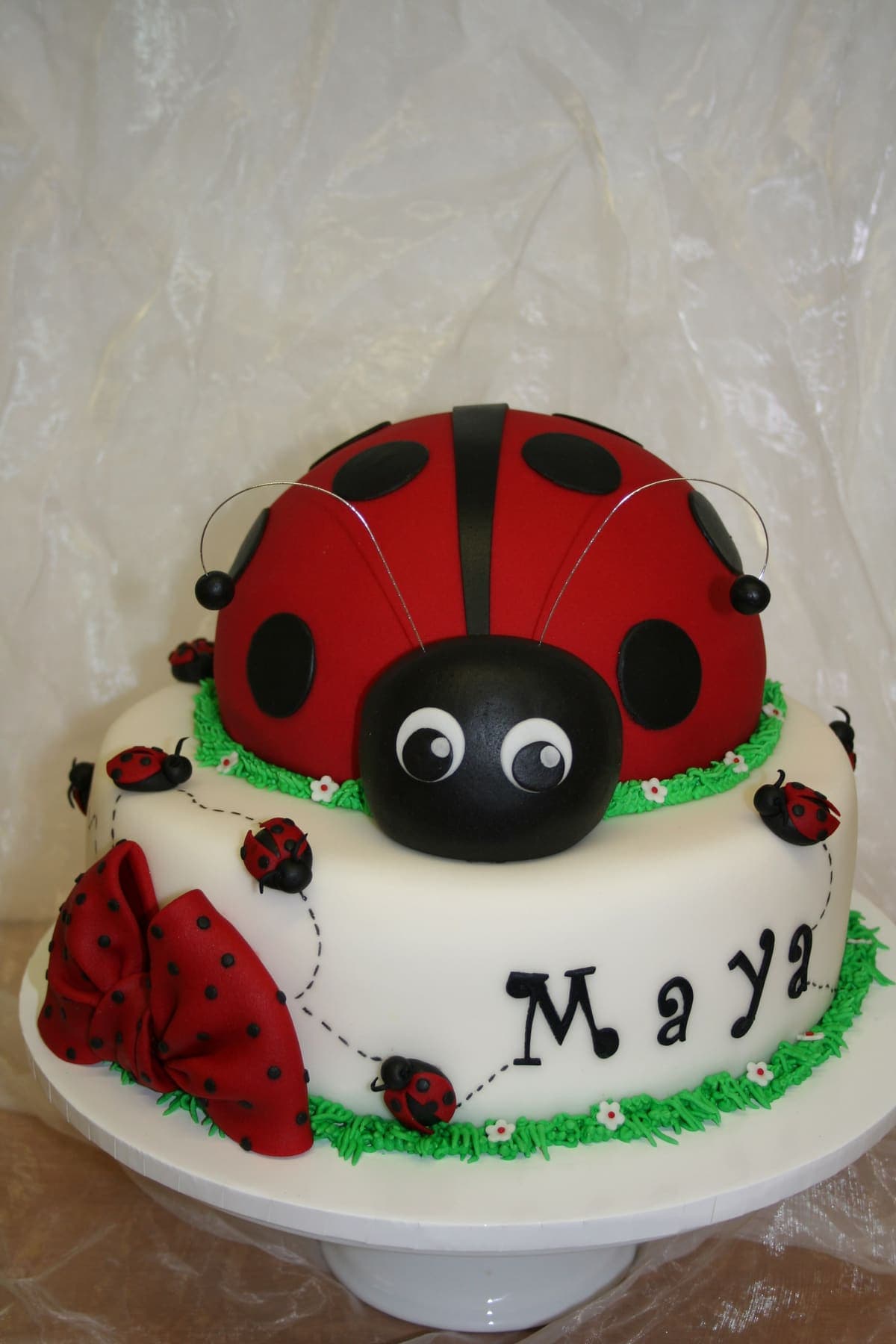 Süße Marienkäfer-Torte mit grünem Gras und kleinen Käfern