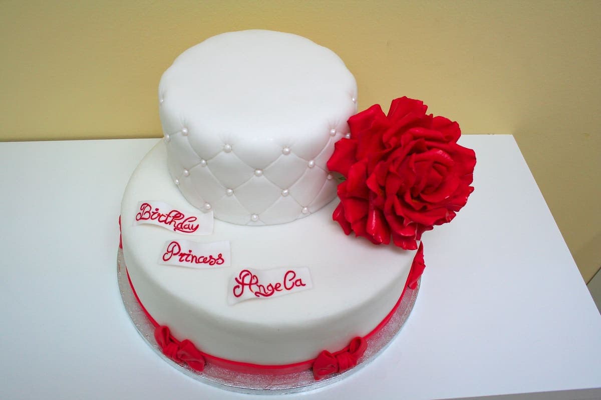 Zweistöckige Prinzessinnen-Torte mit Steppung und roter Rose