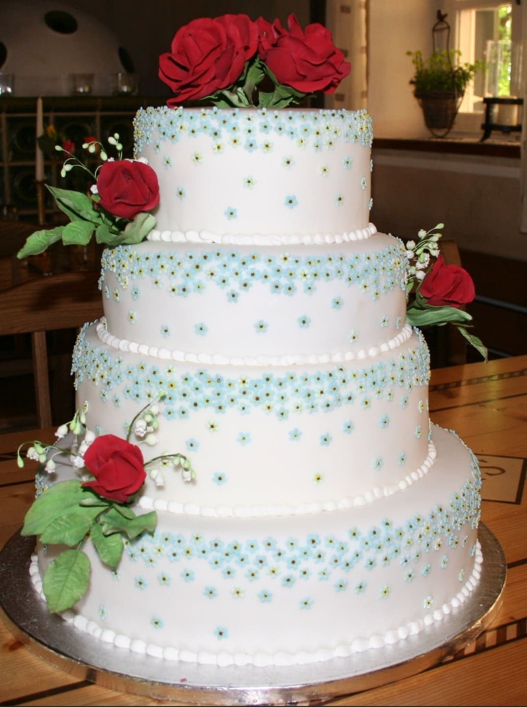 Elegante vierstöckige Hochzeitstorte mit roten Rosen und Perlen Bavaria Cake Konditorei Landshut